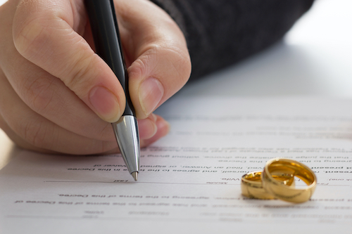 hænder på kone, mand underskriver dekret om skilsmisse, opløsning, annullering af ægteskab, juridiske separationsdokumenter, arkivering af skilsmissepapirer eller førægteskabelig aftale udarbejdet af advokat. Vielsesring.