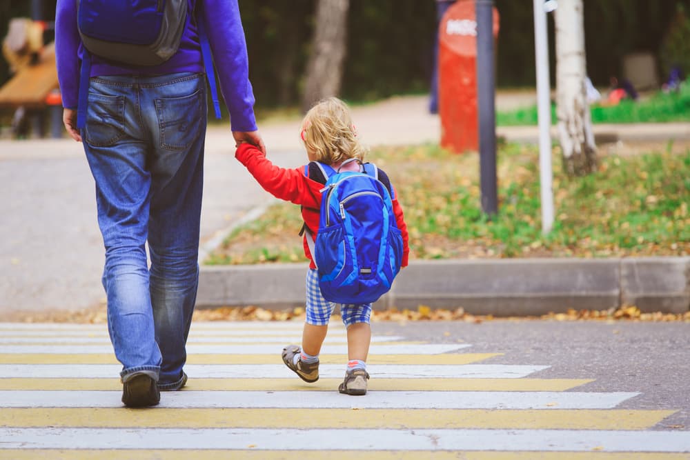 Father walking his little daughter to school.