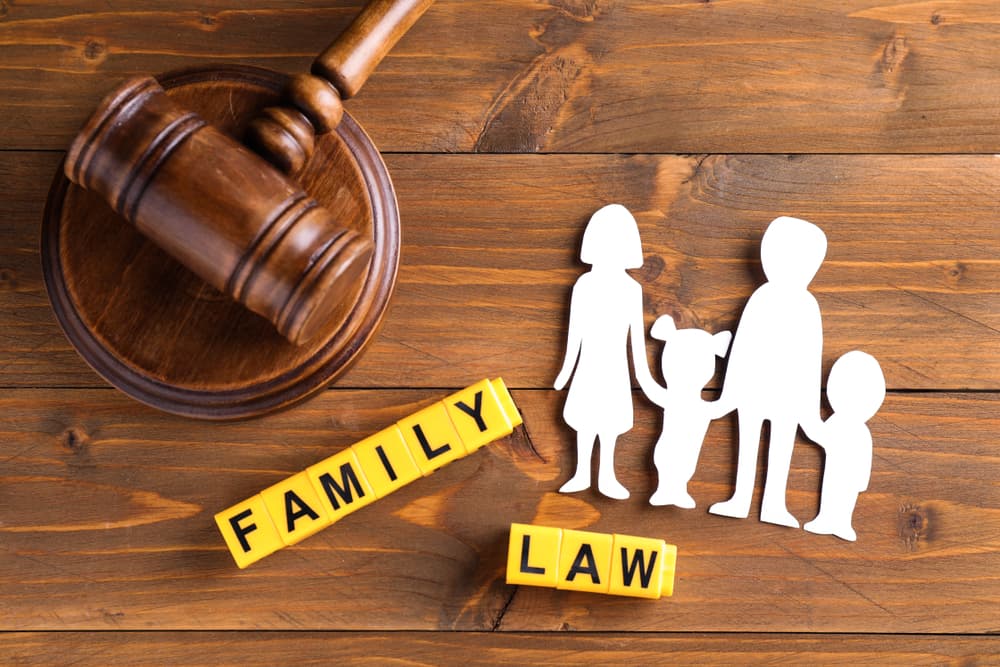 Flat lay with figure and gavel on wooden background: Family law concept.